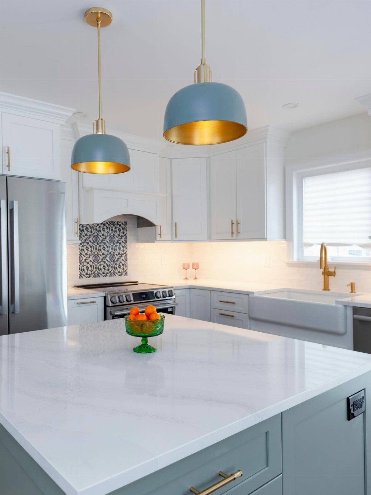 28 Kitchen Cabinets Remodel Ideas and Photos to Try in 2026 7 White and grey kitchen with quartz countertops and blue pendant lights over an island.