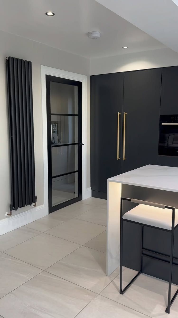 28 Kitchen Cabinets Remodel Ideas and Photos to Try in 2026 9 Dark grey flat-panel kitchen cabinets with gold handles and a white quartz island.