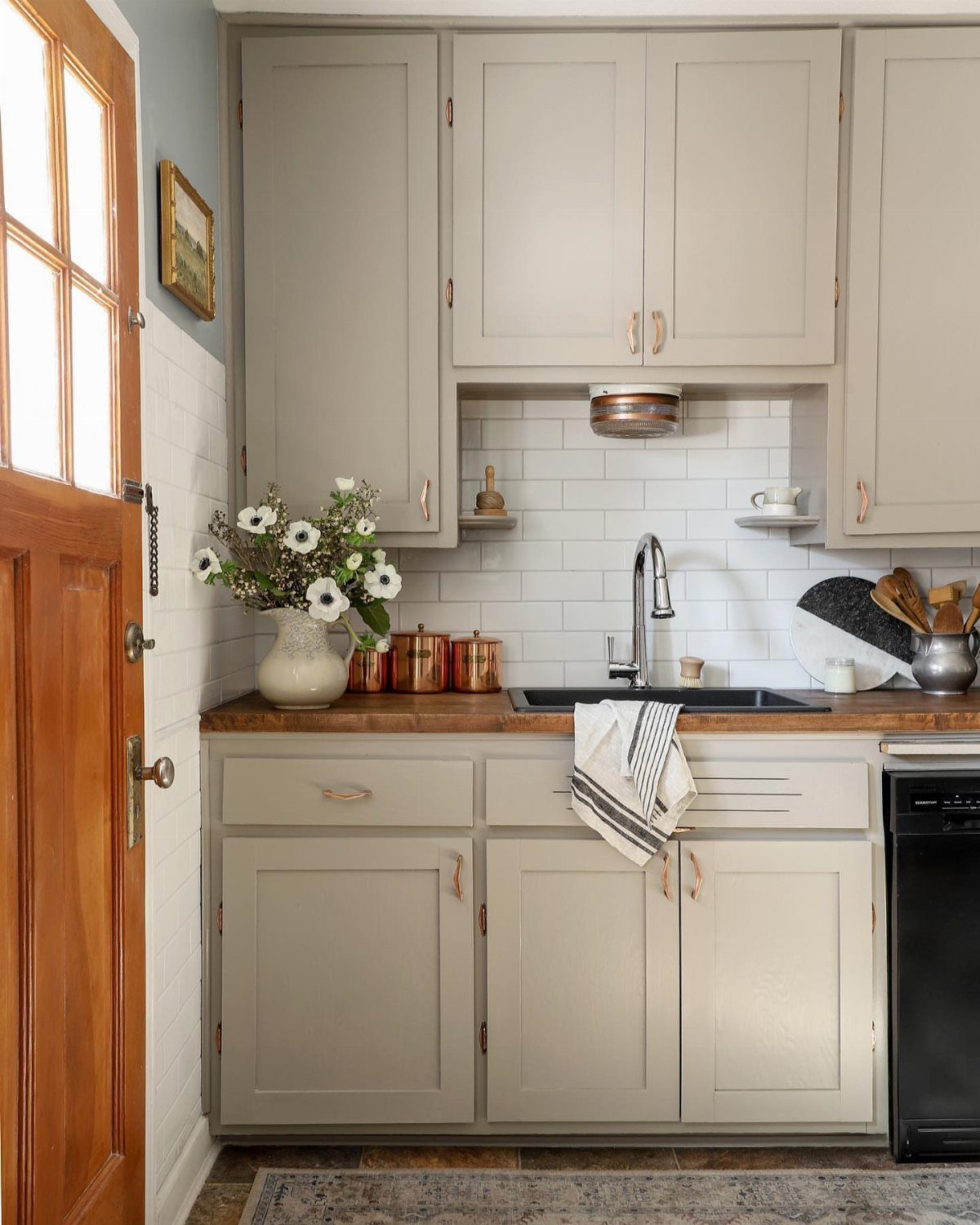 28 Kitchen Cabinets Remodel Ideas and Photos to Try in 2026 6 Light grey kitchen cabinets with gold hardware and a wooden countertop.