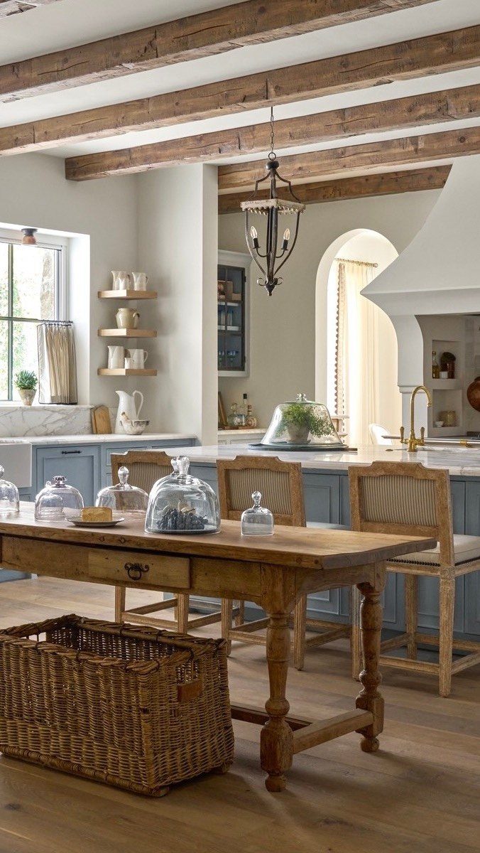 Rustic kitchen with blue cabinets, wooden island, and exposed ceiling beams.