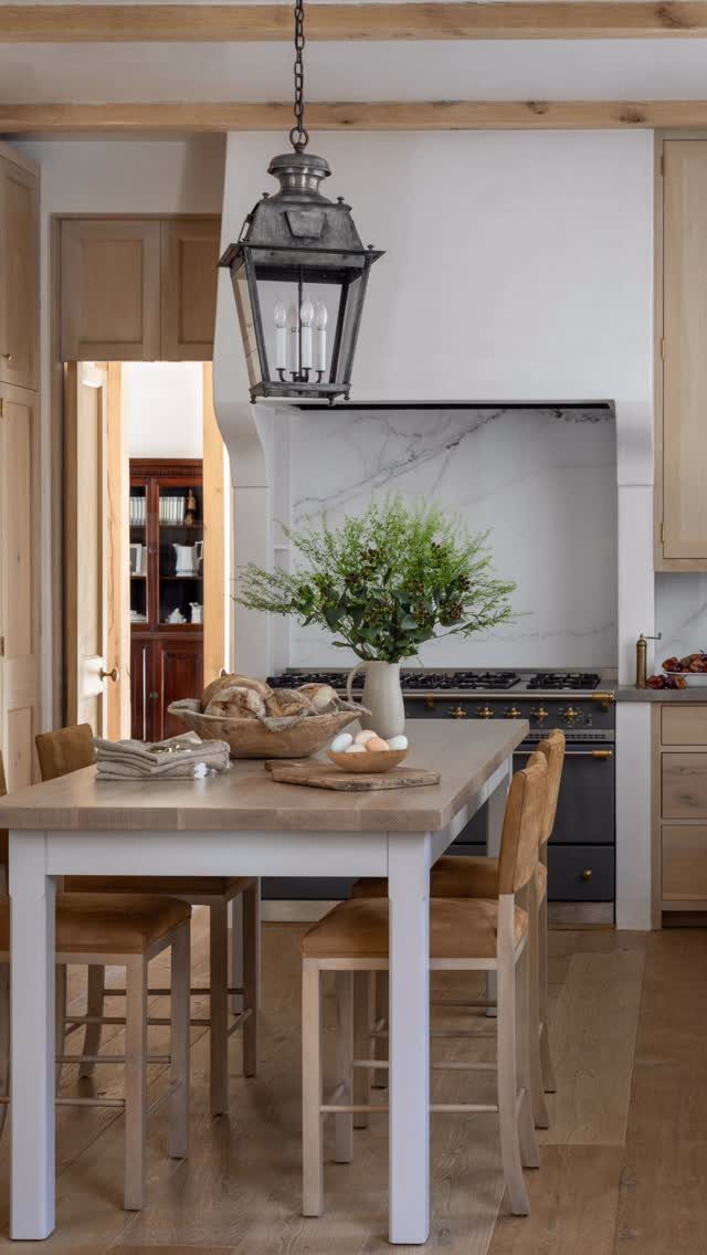 Farmhouse table with white legs and leather chairs in a rustic kitchen setting