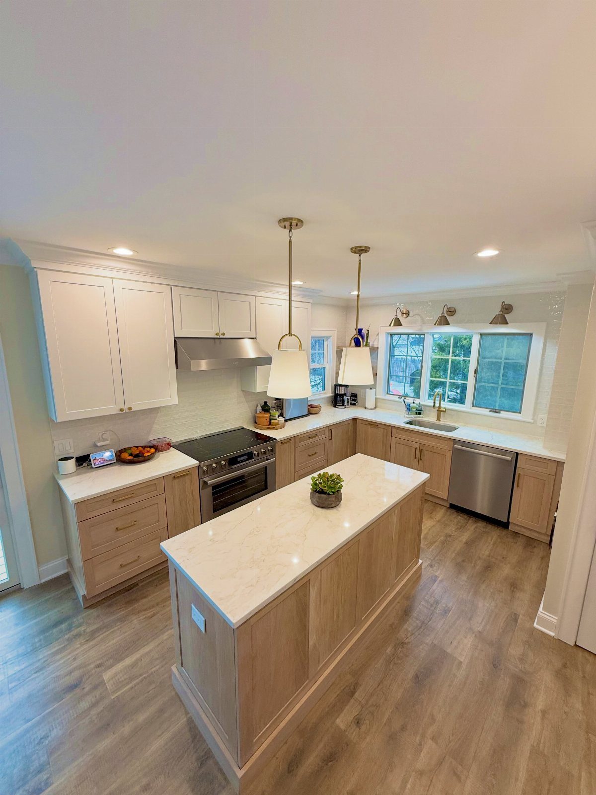 Kitchen with white upper cabinets, light wood lower cabinets, and a white island countertop.