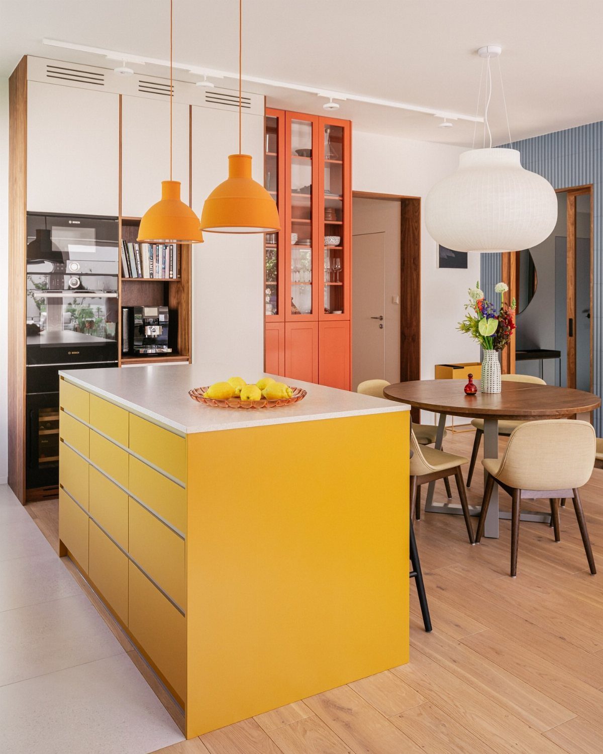 Yellow kitchen island with white countertop and white cabinets in a modern room.