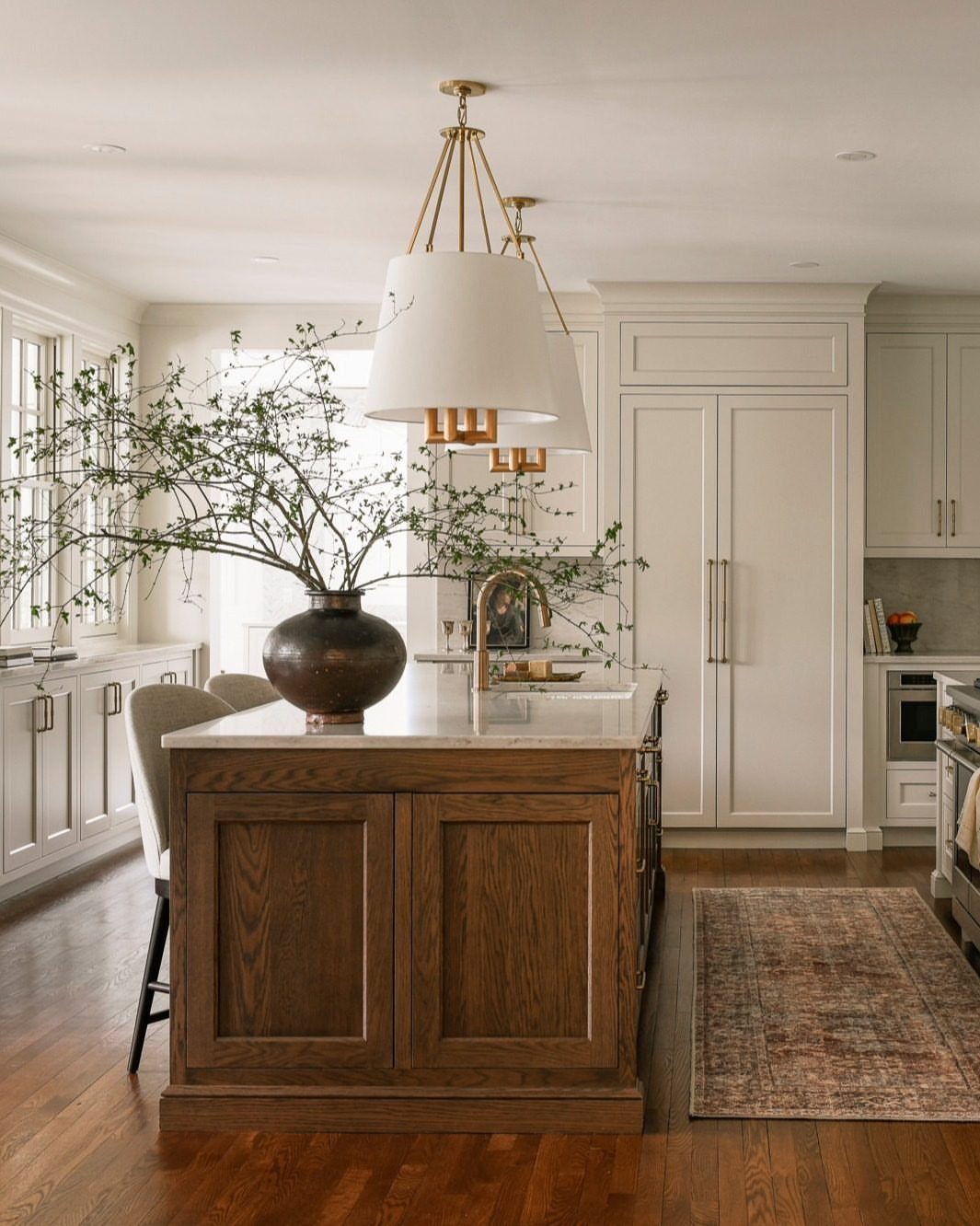 White shaker cabinets and a wooden kitchen island with white marble countertops