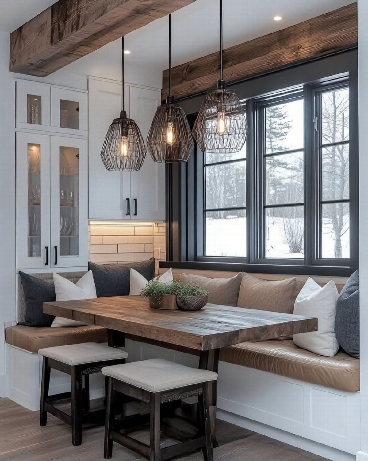 Wooden kitchen table with leather L-shaped banquette seating and two small stools.