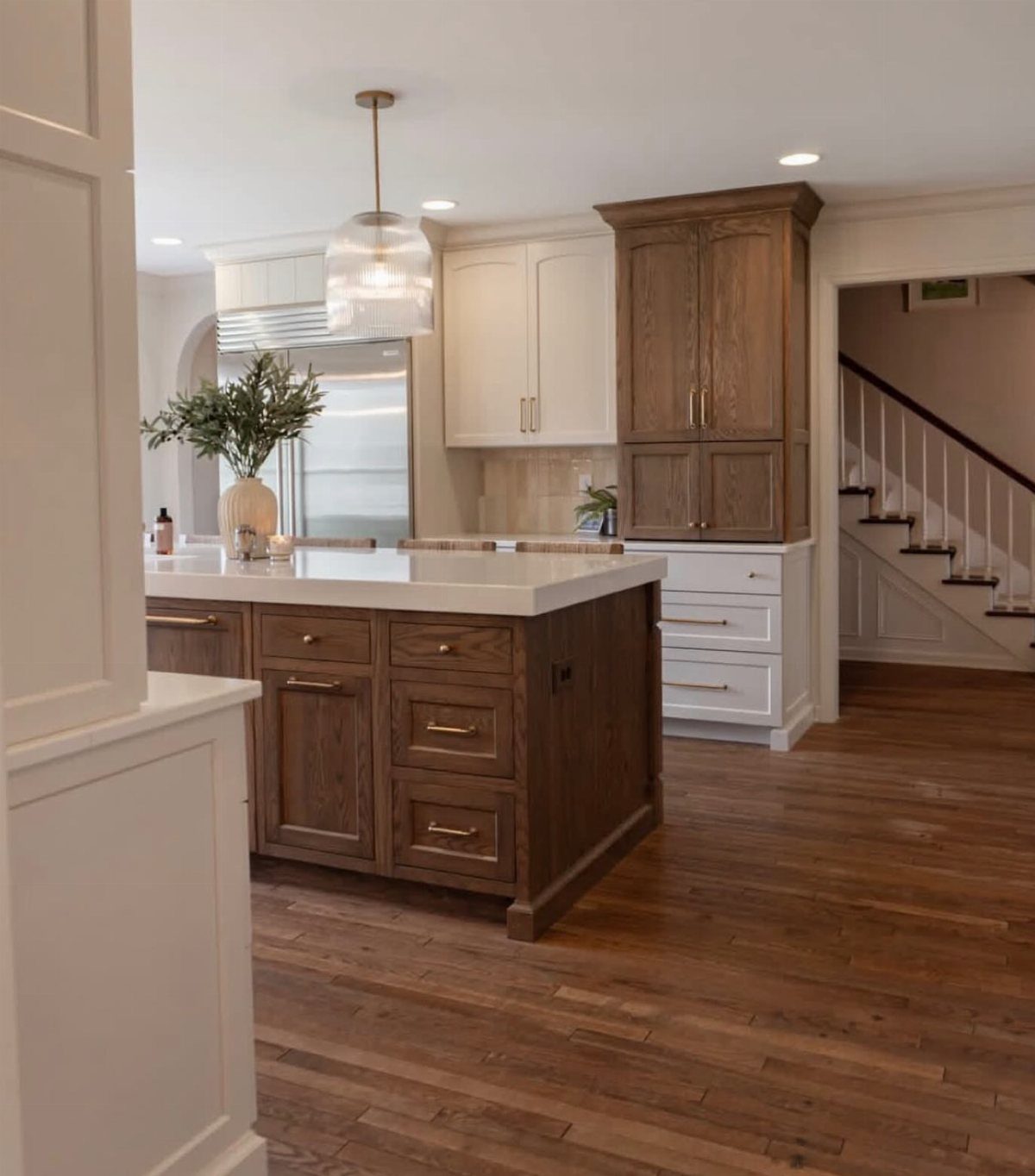 15 Kitchen Style L Shape Ideas, from Islands to Backsplashes 5 Tall wood pantry cabinet next to white kitchen cabinets and a large wood island.