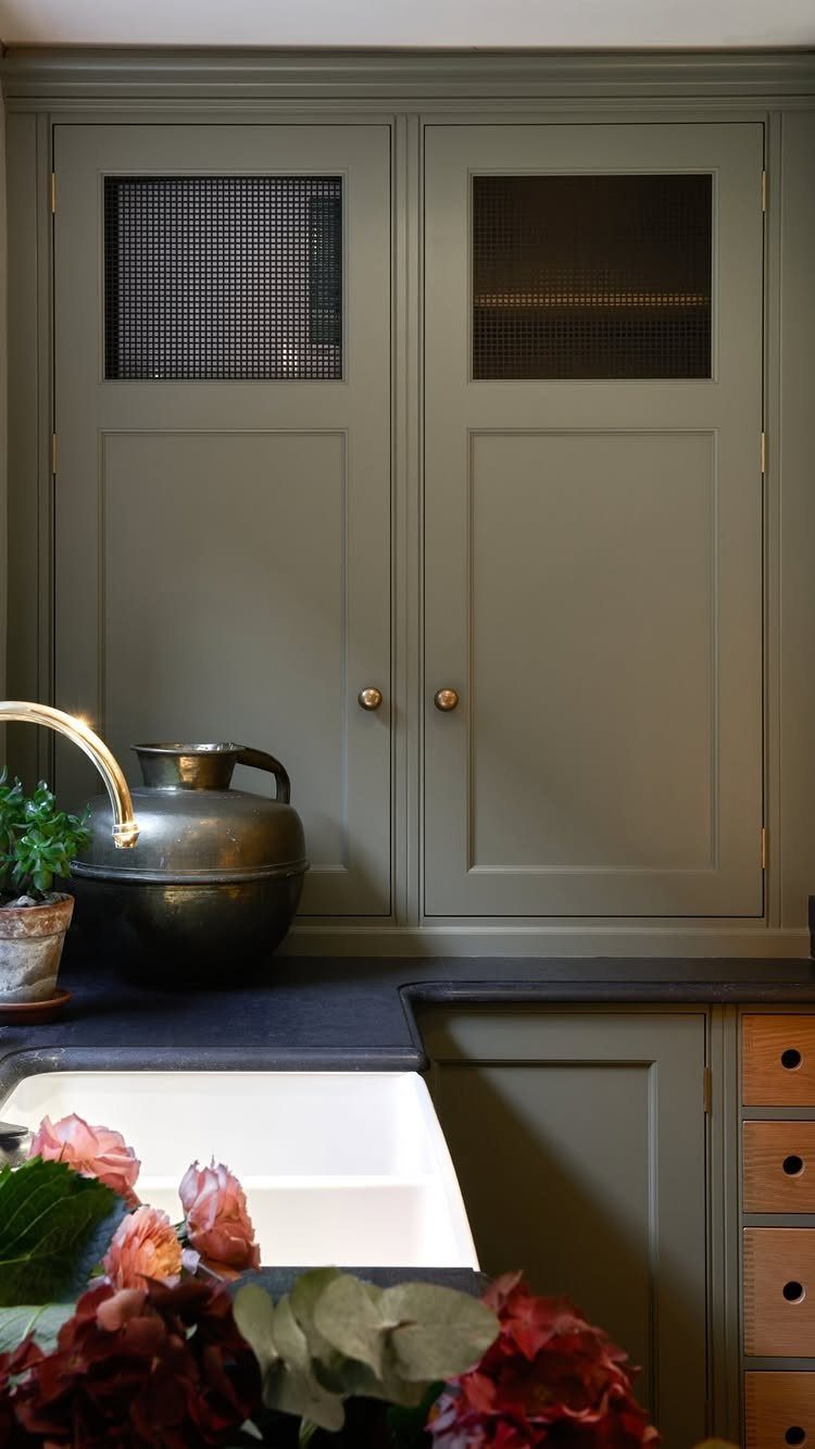 12 Kitchen Updates on a Budget, From Hardware to Pantry Jars 7 Olive green kitchen cabinets with gold hardware and a dark countertop.