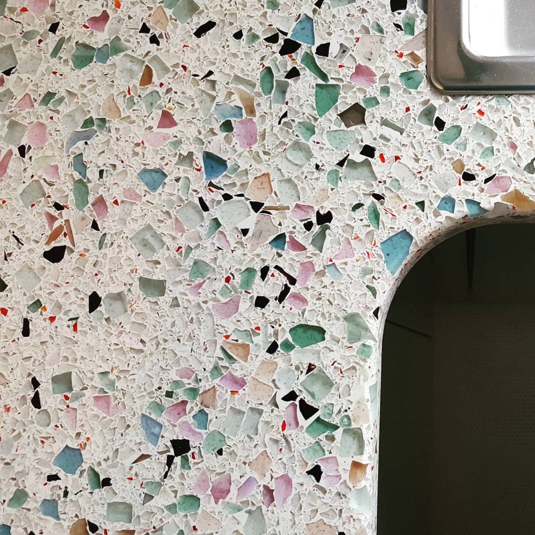 12 Kitchen Updates on a Budget, From Hardware to Pantry Jars 8 Recycled glass countertop with colorful fragments embedded in a white terrazzo surface.