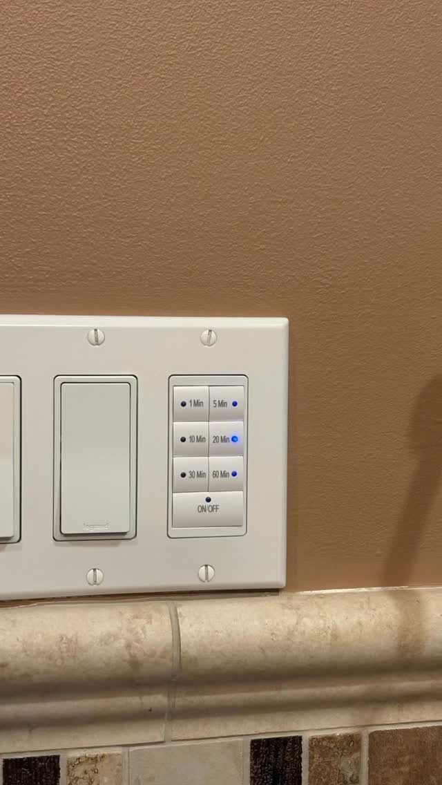 White wall plate with a light switch and a digital timer switch.