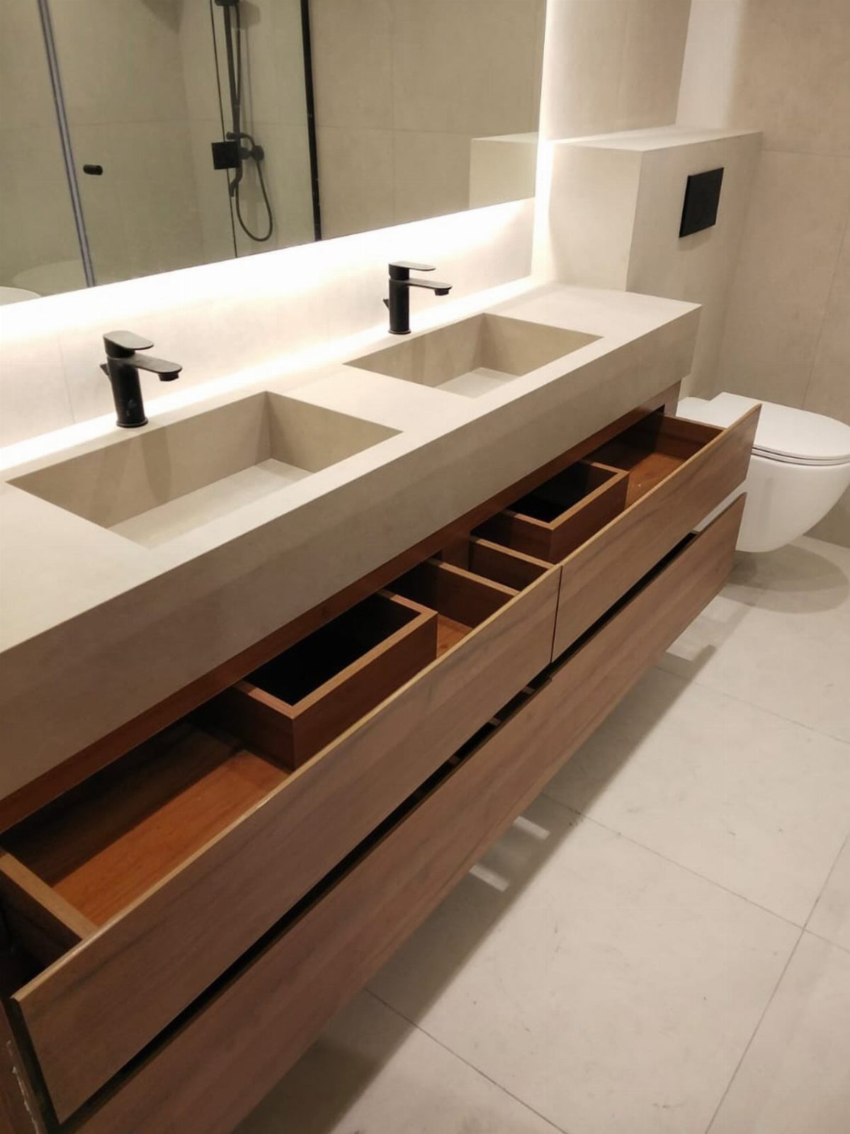 Modern double vanity with beige sinks and wooden drawers in a large bathroom