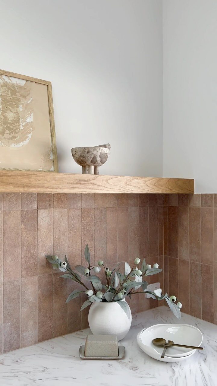 10 Mid Century Modern Kitchen Remodel Ideas for Your Home 3 Matte brown vertical stacked tiles backsplash with a wood floating shelf and marble countertop.