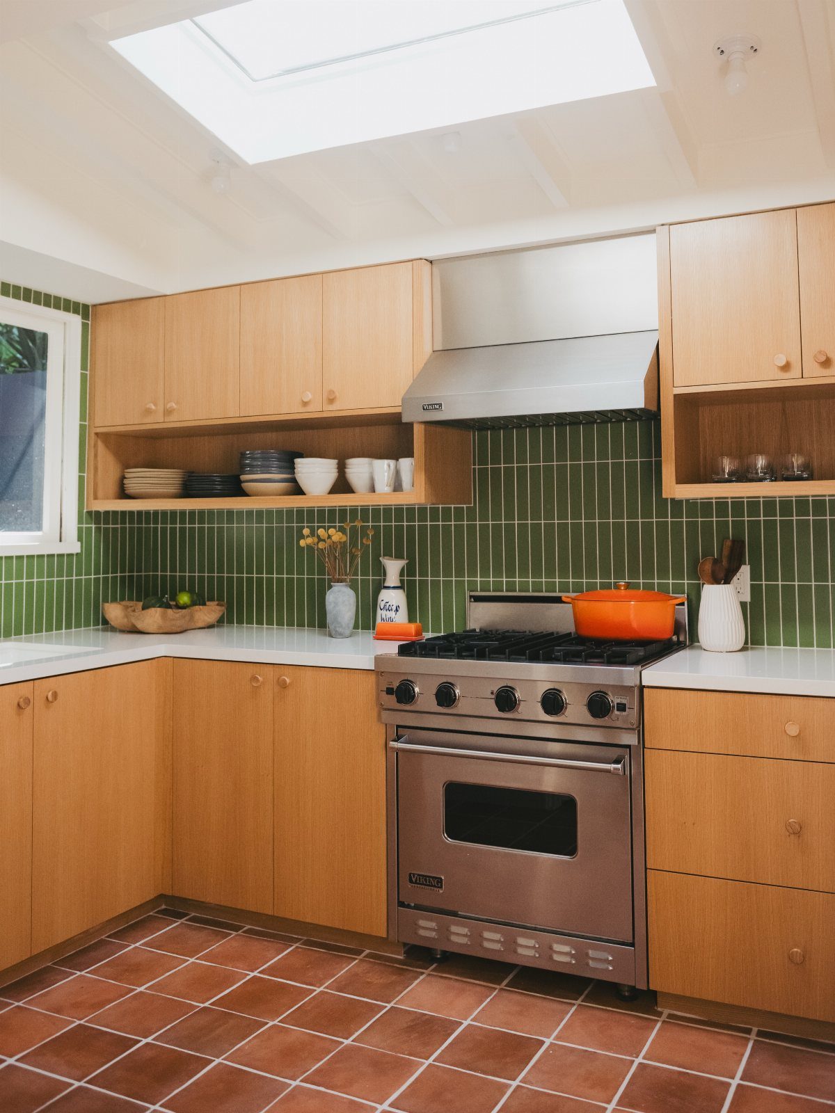 10 Mid Century Modern Kitchen Remodel Ideas for Your Home 8 White quartz countertops in a kitchen with light wood cabinets and green tiles.