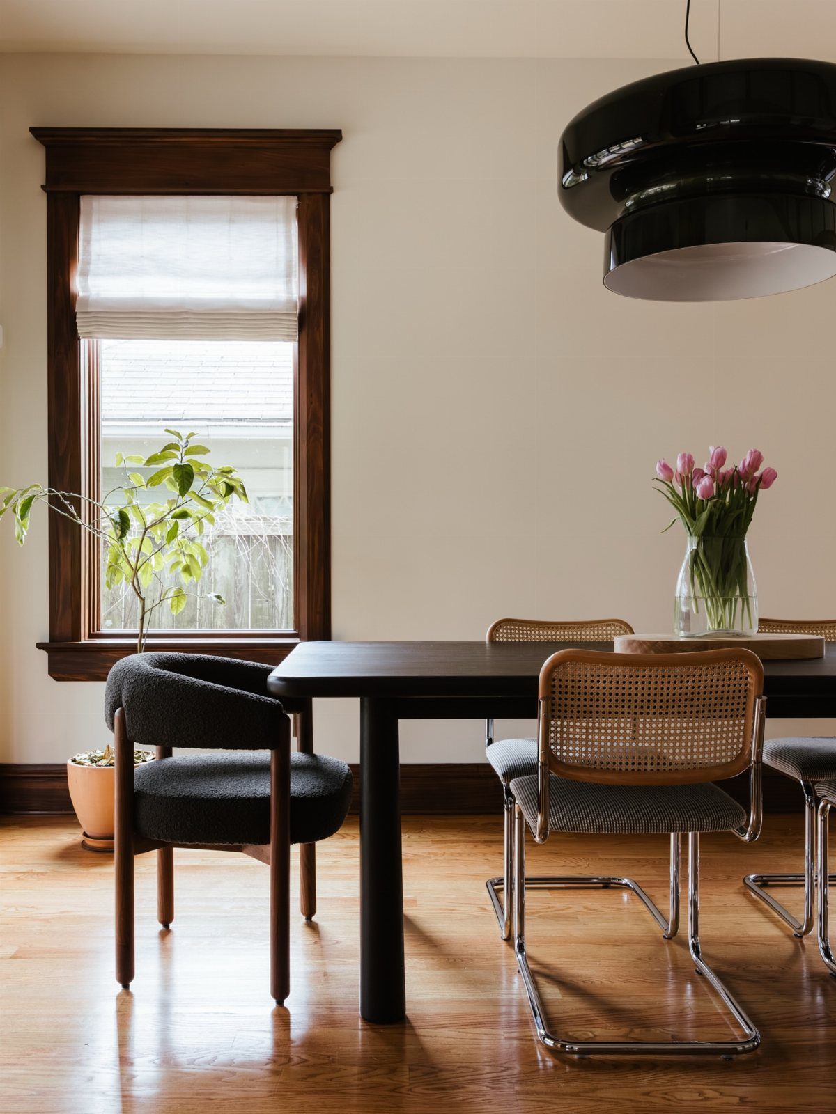 Mismatched Chairs Dining Table: 12 Ideas for a Cohesive Look 3 Dark wood dining table with a grey upholstered chair and cane-backed chairs.