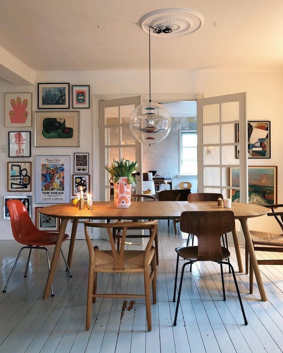 Mismatched Chairs Dining Table: 12 Ideas for a Cohesive Look 7 Simple wooden dining table surrounded by mismatched red, cane, and dark wood chairs.