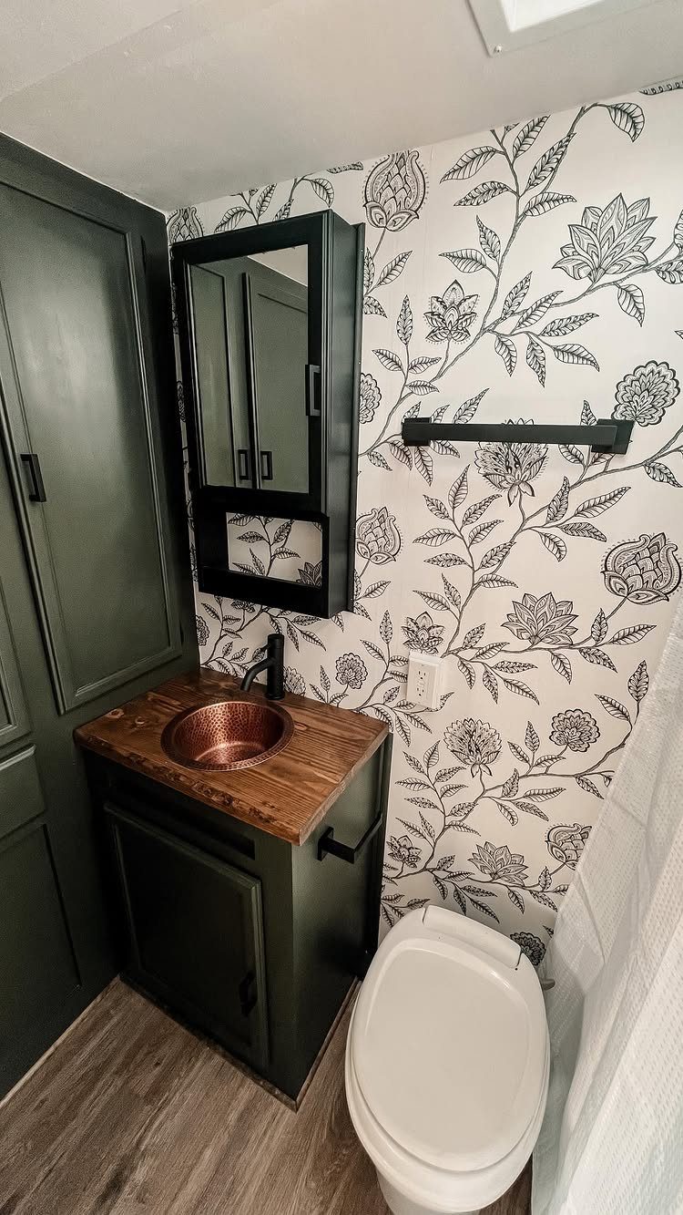 12 Mobile Home Master Bath Remodel Ideas and Moisture Tips 9 Small bathroom with dark green vanity, copper sink, and black and white floral wallpaper.