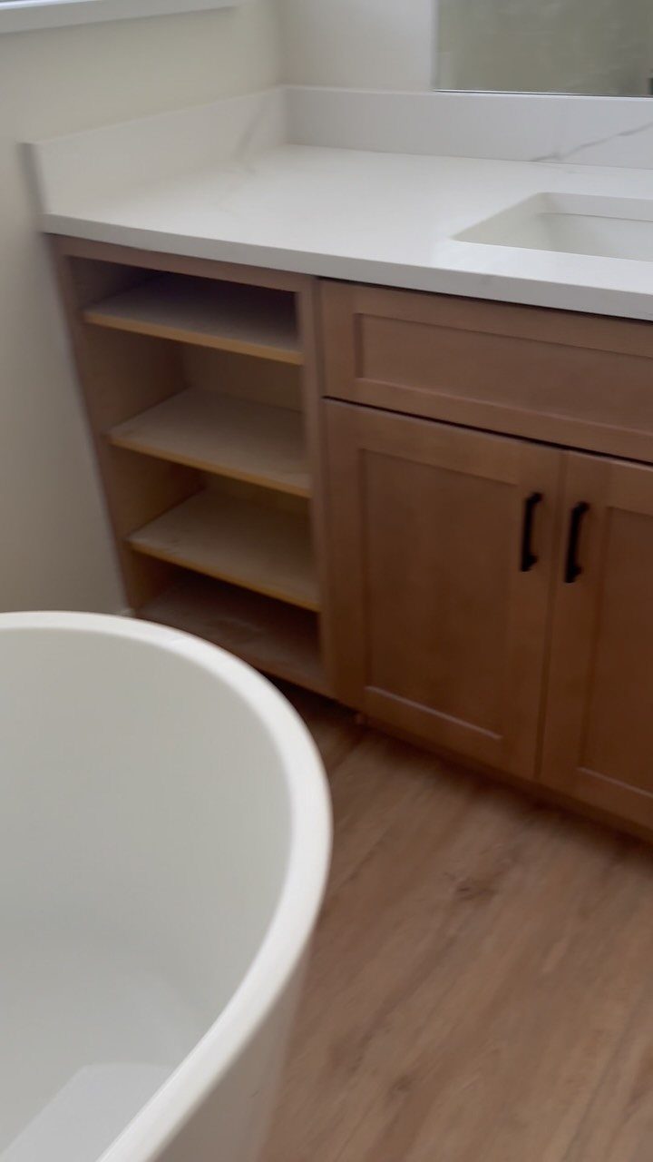 12 Mobile Home Master Bath Remodel Ideas and Moisture Tips 10 White bathroom vanity with wooden cabinets and a white freestanding bathtub.