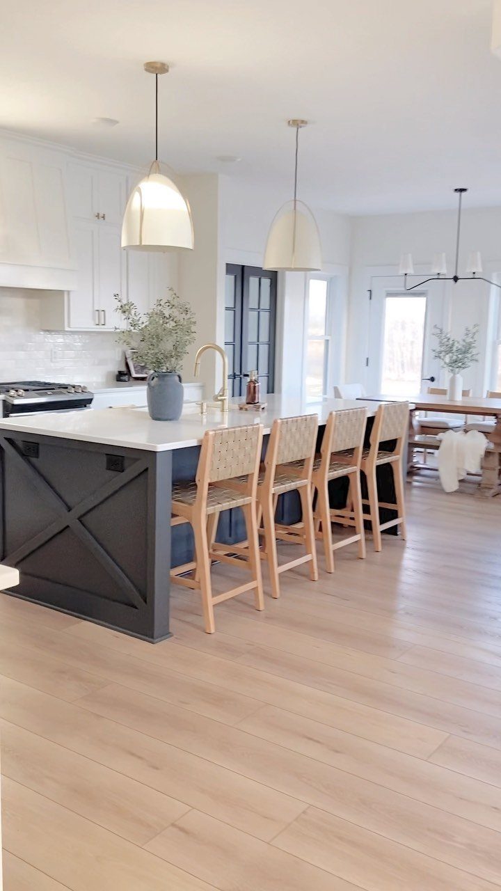 Neutral Kitchen Cabinets: 16 Colors From Greige to Black 12 Dark charcoal gray kitchen island with white countertops and woven rattan bar stools.