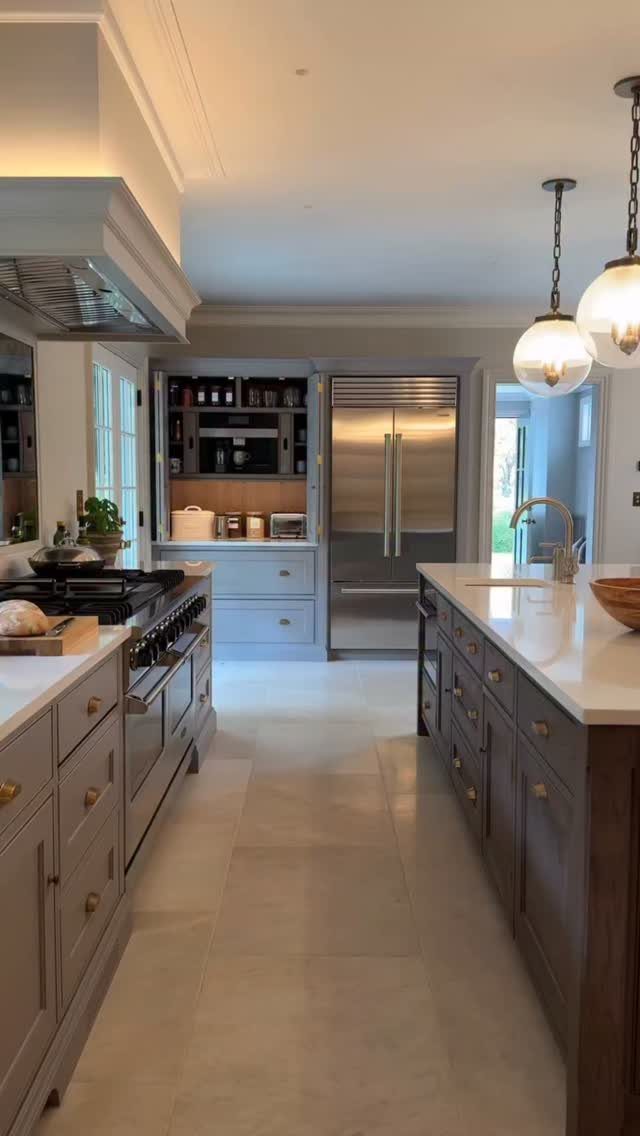 Neutral Kitchen Cabinets: 16 Colors From Greige to Black 2 Light gray kitchen cabinets with white countertops and globe pendant lighting in a spacious room.
