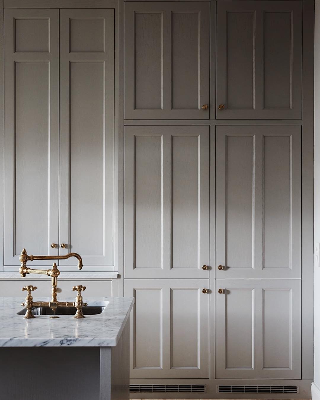 Neutral Kitchen Cabinets: 16 Colors From Greige to Black 10 Gray-green shaker kitchen cabinets with gold hardware and a white marble countertop.