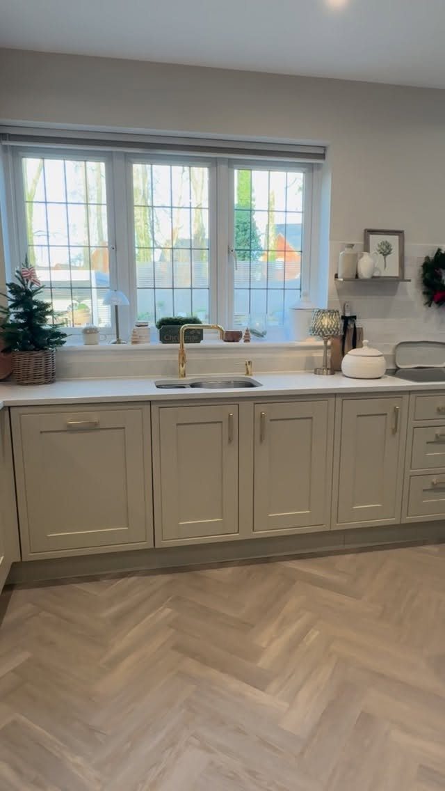 Neutral Kitchen Cabinets: 16 Colors From Greige to Black 15 Light taupe shaker kitchen cabinets with white countertops and herringbone wood flooring.