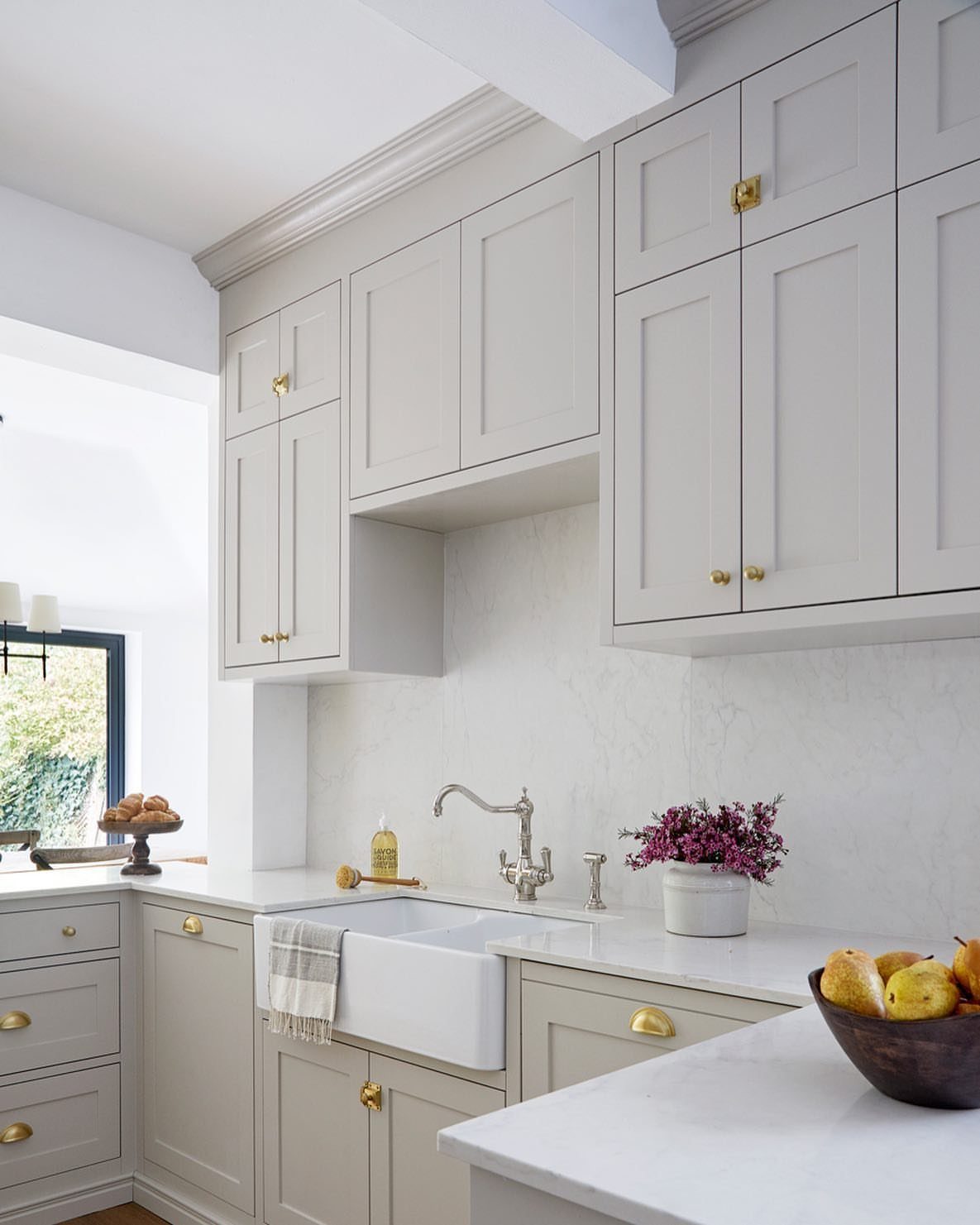 Neutral Kitchen Cabinets: 16 Colors From Greige to Black 9 Light greige shaker kitchen cabinets with gold hardware and a white farmhouse sink.