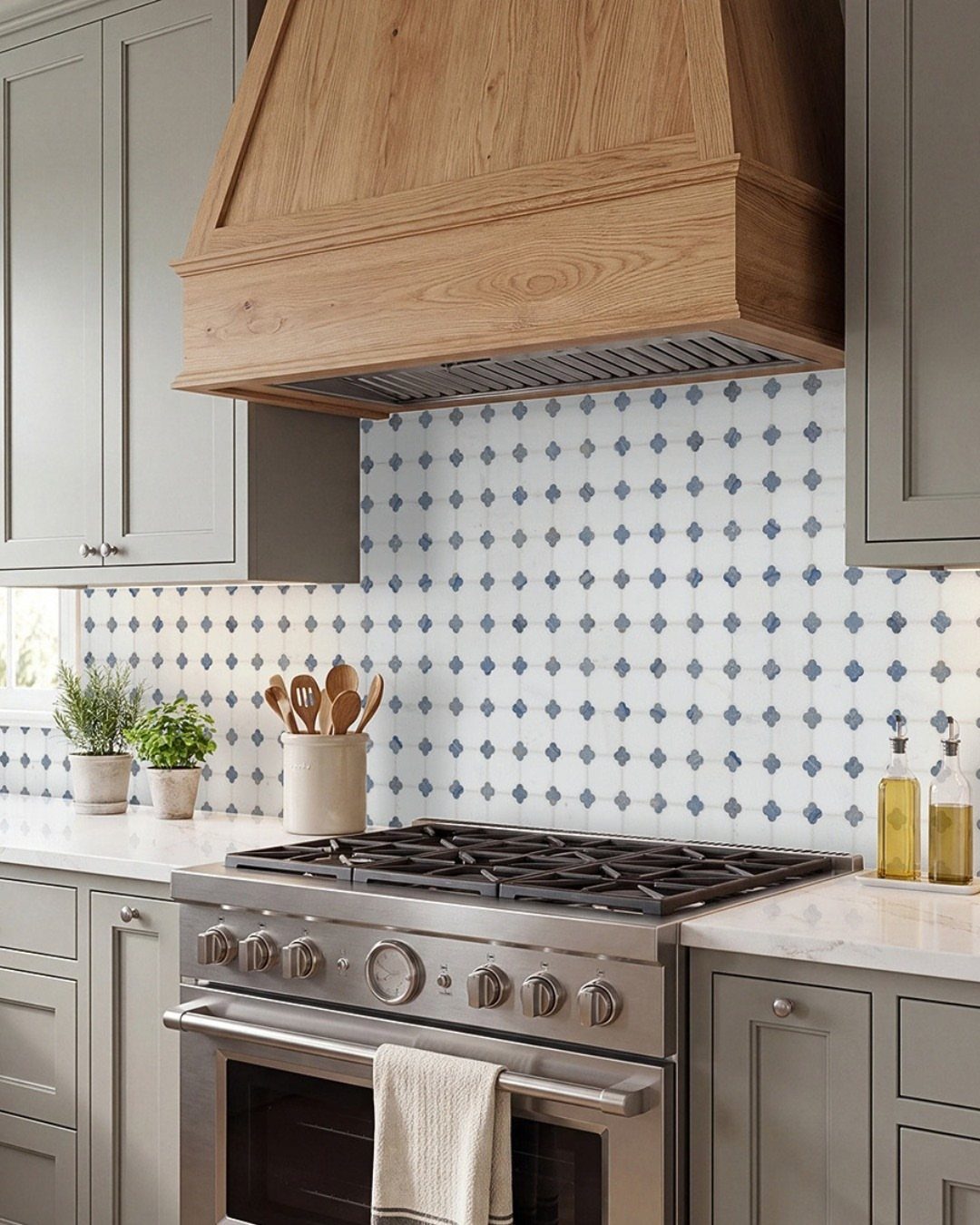 Kitchen with a blue and white diamond pattern backsplash and wooden range hood.
