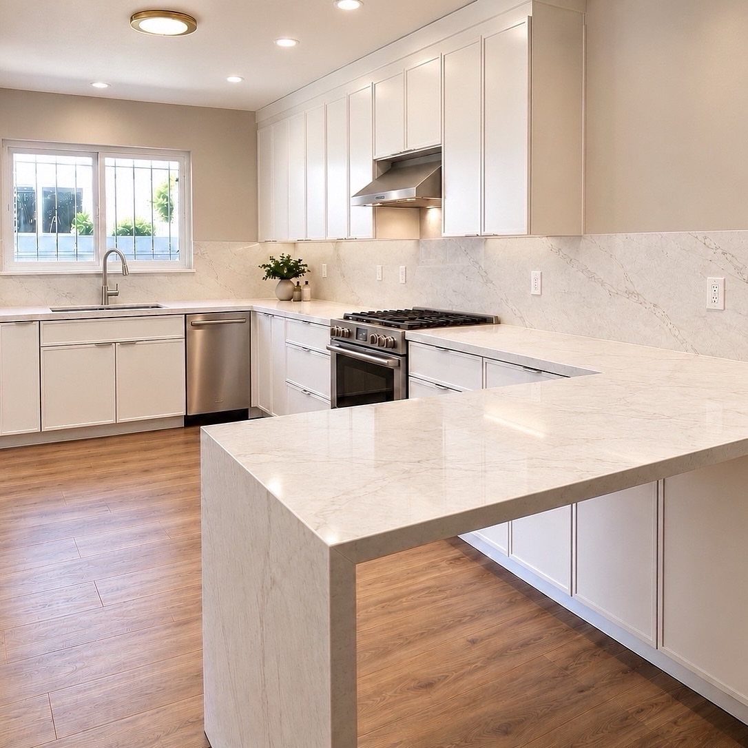 White kitchen with marble countertops, flat-panel cabinets, and a large central marble island.