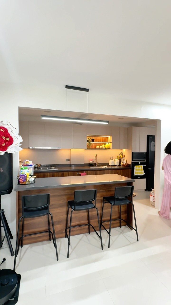 Kitchen island with grey countertop and black bar stools in a modern kitchen