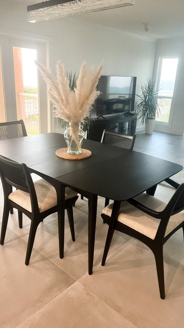 Painting Kitchen Table Ideas: 11 Looks From Yellow to Black 4 Black dining table with matching chairs and pampas grass in a bright room