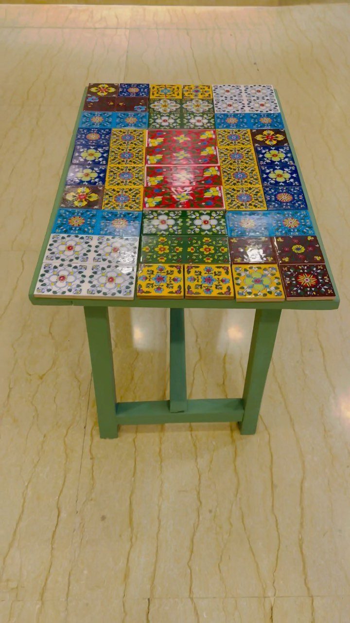 Painting Kitchen Table Ideas: 11 Looks From Yellow to Black 7 Tiled kitchen table with colorful patterned ceramics and green painted legs on marble floor.
