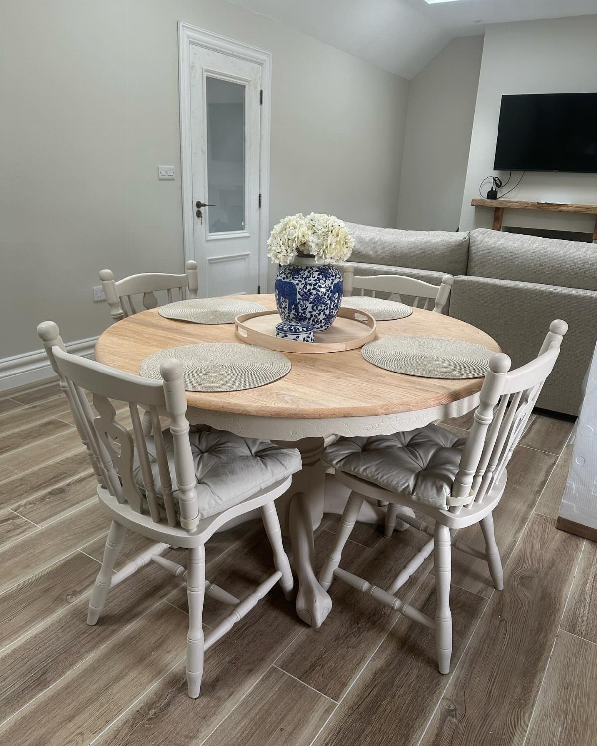 Painting Kitchen Table Ideas: 11 Looks From Yellow to Black 3 Round white farmhouse table with a natural wood top and matching white chairs.