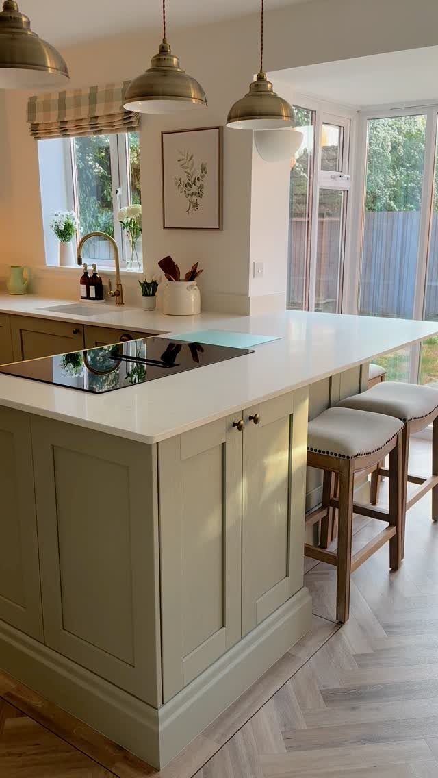15 Ranch Style House Kitchen Remodel Ideas, Retro to Modern 13 Light green peninsula kitchen counter with white top, cooktop, and wooden bar stools.