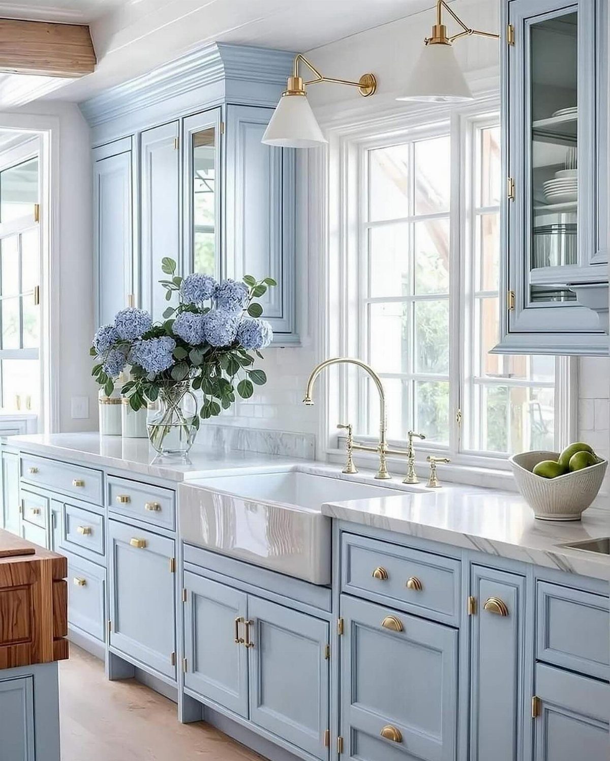 15 Ranch Style House Kitchen Remodel Ideas, Retro to Modern 9 Soft blue kitchen cabinets with a white farmhouse sink and gold hardware.