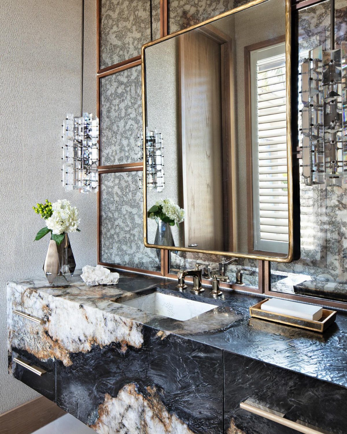 17 Remodeling Old House Ideas for Kitchens, Baths, Offices 5 Gold-framed mirror and patterned wallpaper above a dark marbled stone bathroom vanity.