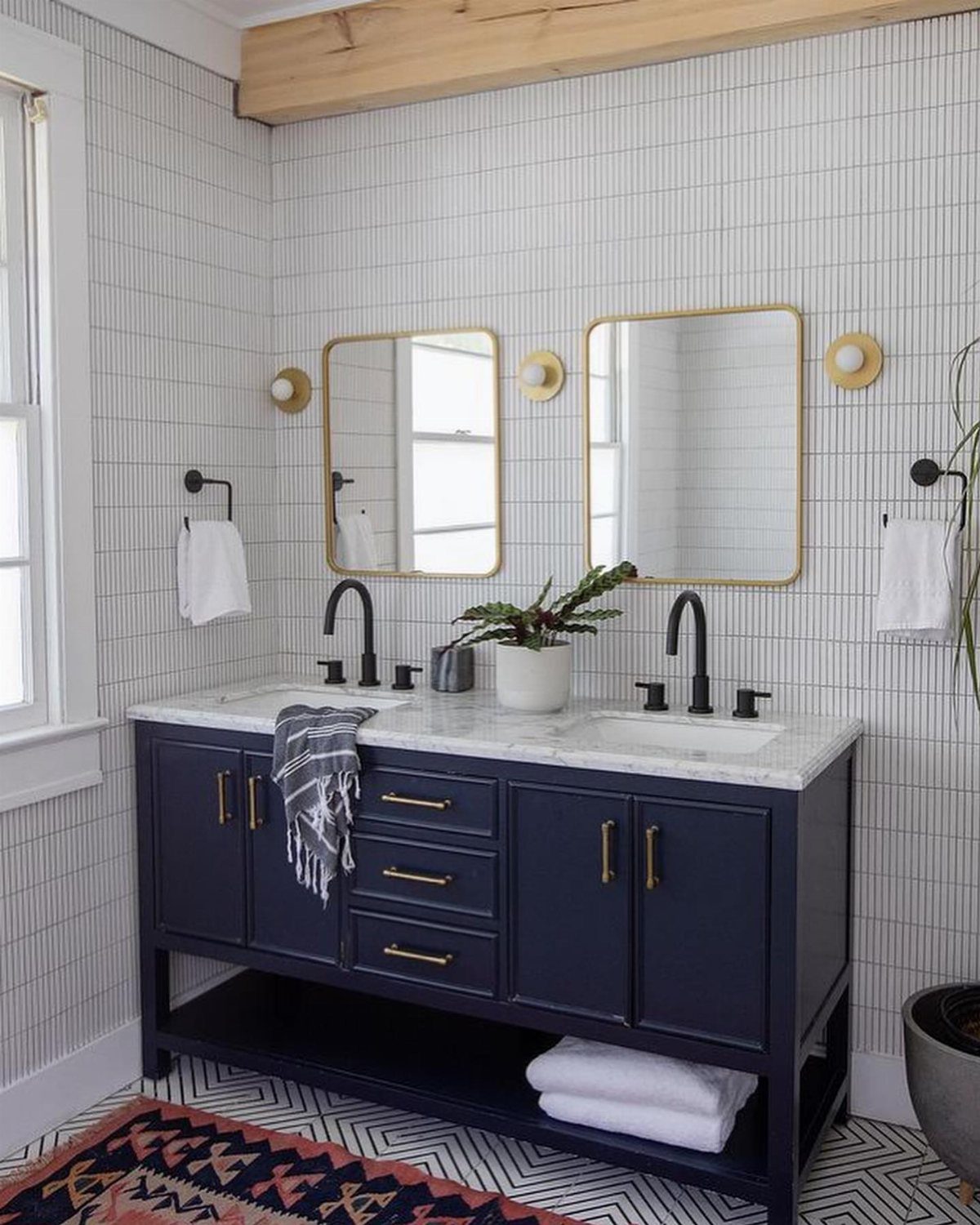 17 Remodeling Old House Ideas for Kitchens, Baths, Offices 3 Navy blue double vanity with gold hardware and mirrors in a white tiled bathroom.