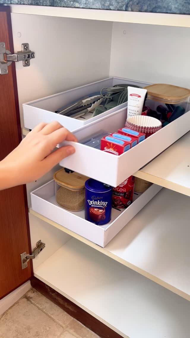 17 Remodeling Old House Ideas for Kitchens, Baths, Offices 6 Hand pulling out a white plastic storage bin from a white kitchen cabinet.