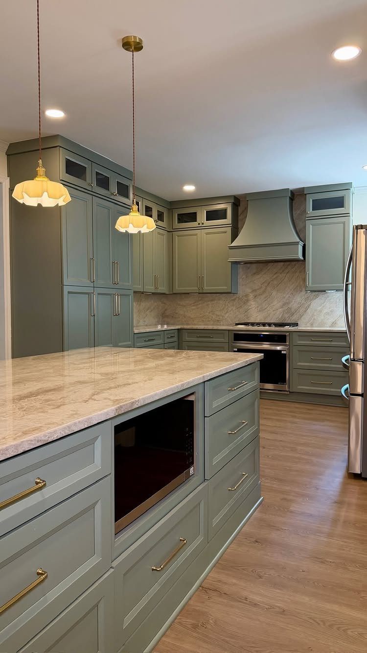 26 Sage Green Kitchen Ideas Using Wood, Brass, and Marble 4 Sage green kitchen cabinets with elegant brass hardware and marble countertops.
