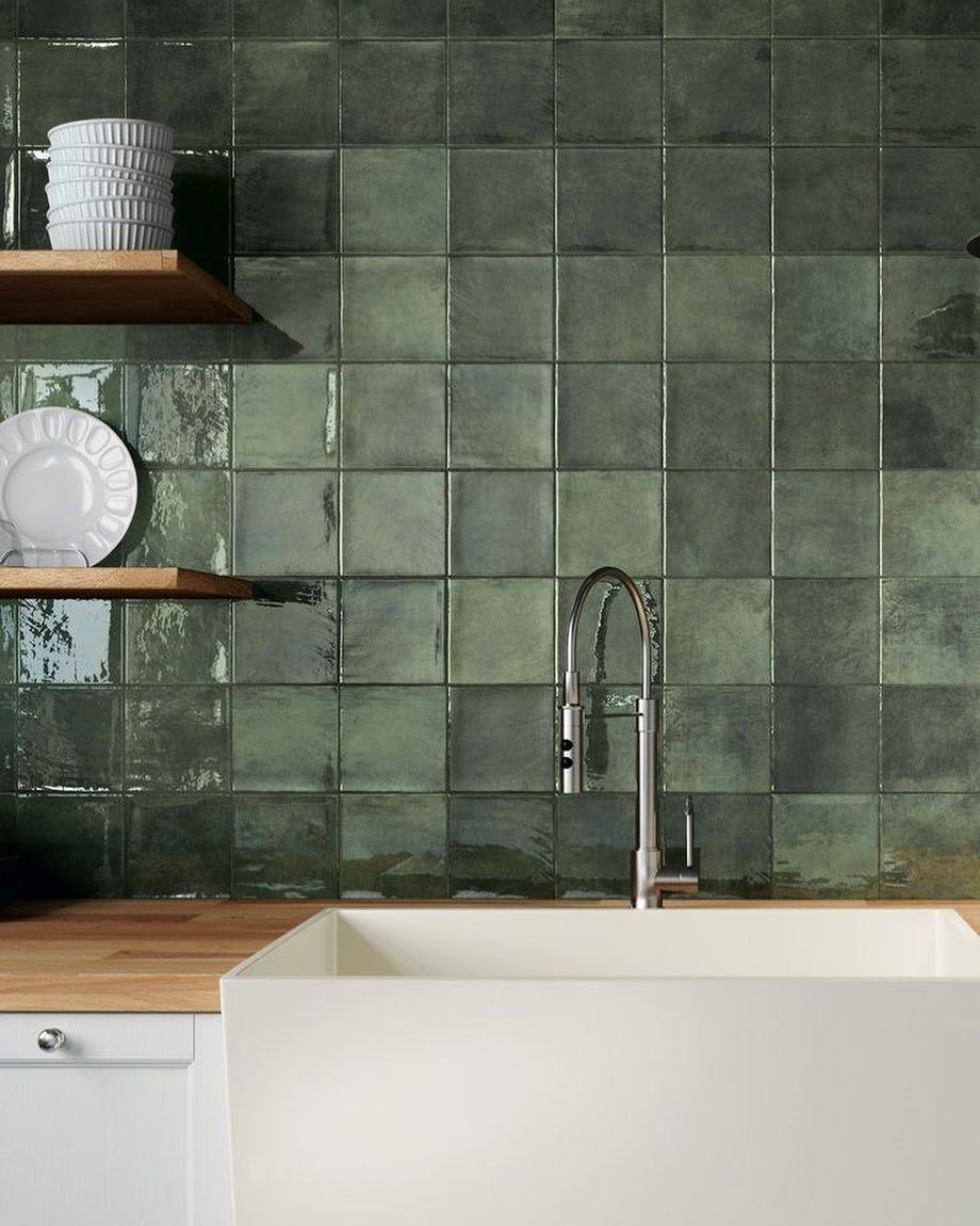 26 Sage Green Kitchen Ideas Using Wood, Brass, and Marble 17 Sage green square tiles on a kitchen wall with a white farmhouse sink.