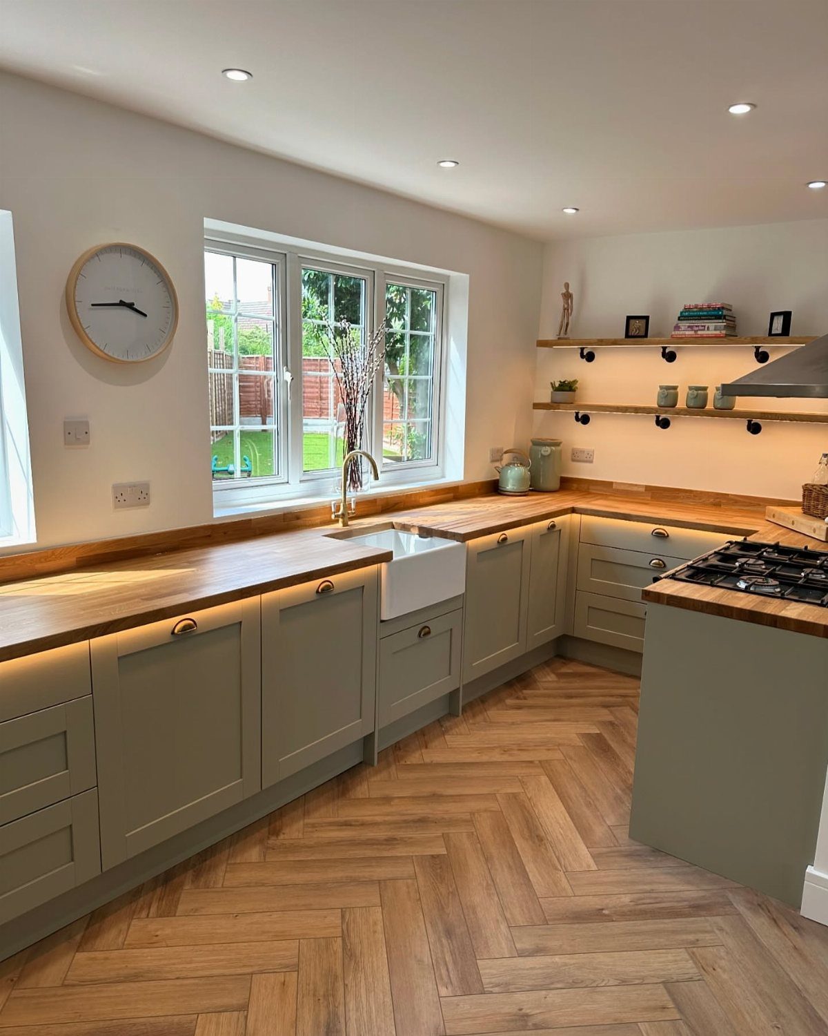 26 Sage Green Kitchen Ideas Using Wood, Brass, and Marble 23 Sage green kitchen cabinets with oak wood countertops and herringbone oak flooring.