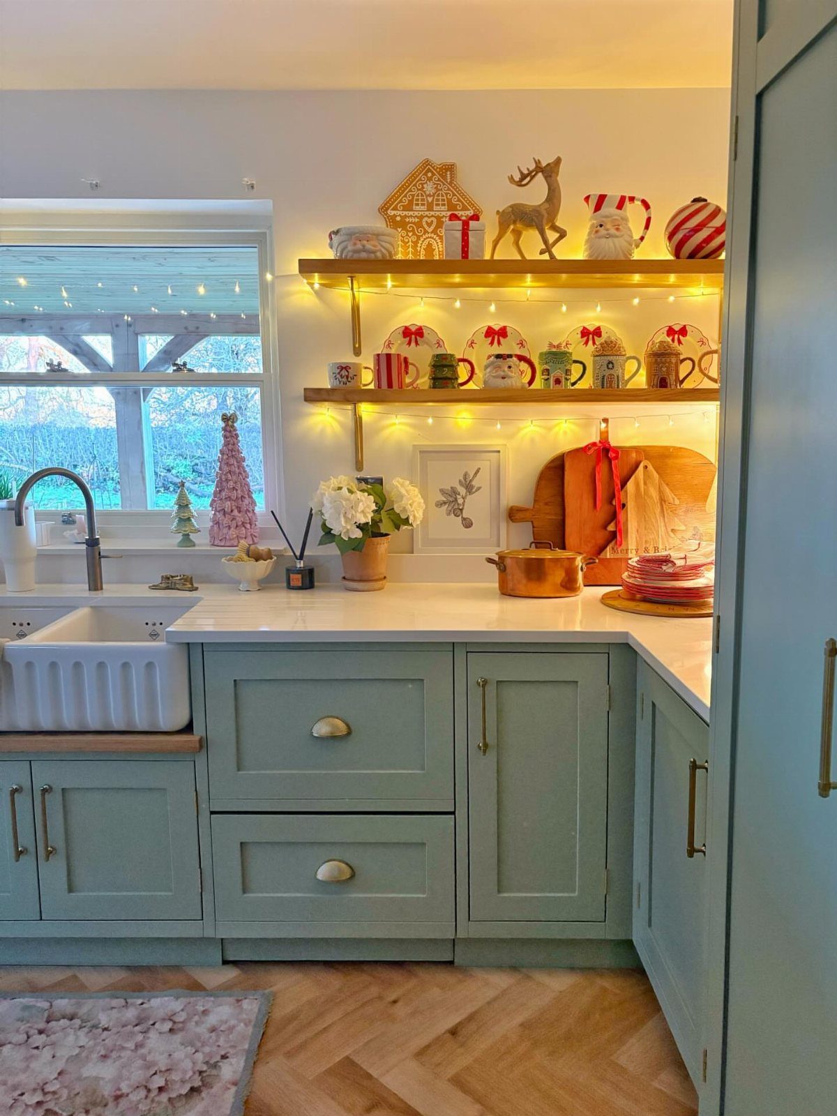 UK Kitchen Ideas Green: 21 Cabinet, Tile and Worktop Looks 19 Sage green kitchen cabinets with a white farmhouse sink and festive Christmas decorations.