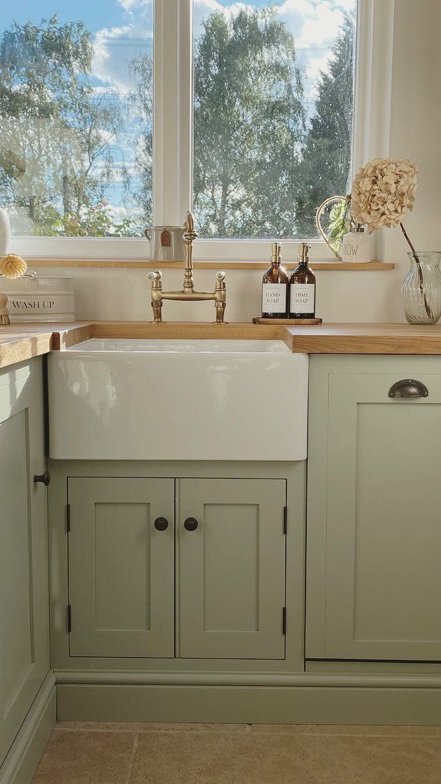 UK Kitchen Ideas Green: 21 Cabinet, Tile and Worktop Looks 3 Sage green kitchen cabinets with a white farmhouse sink and wooden countertops.