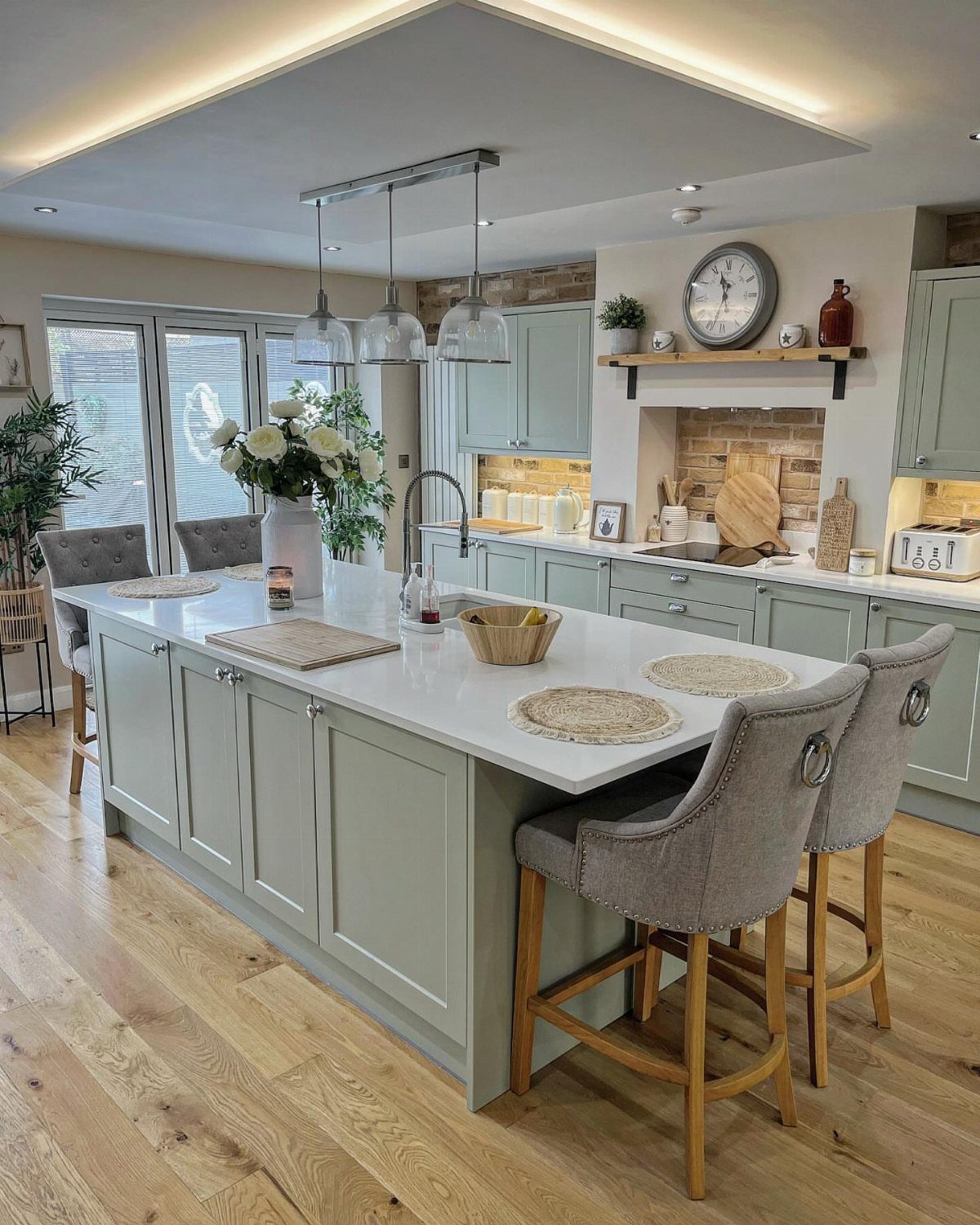UK Kitchen Ideas Green: 21 Cabinet, Tile and Worktop Looks 2 Soft green kitchen cabinets with a white island and light wood floors.