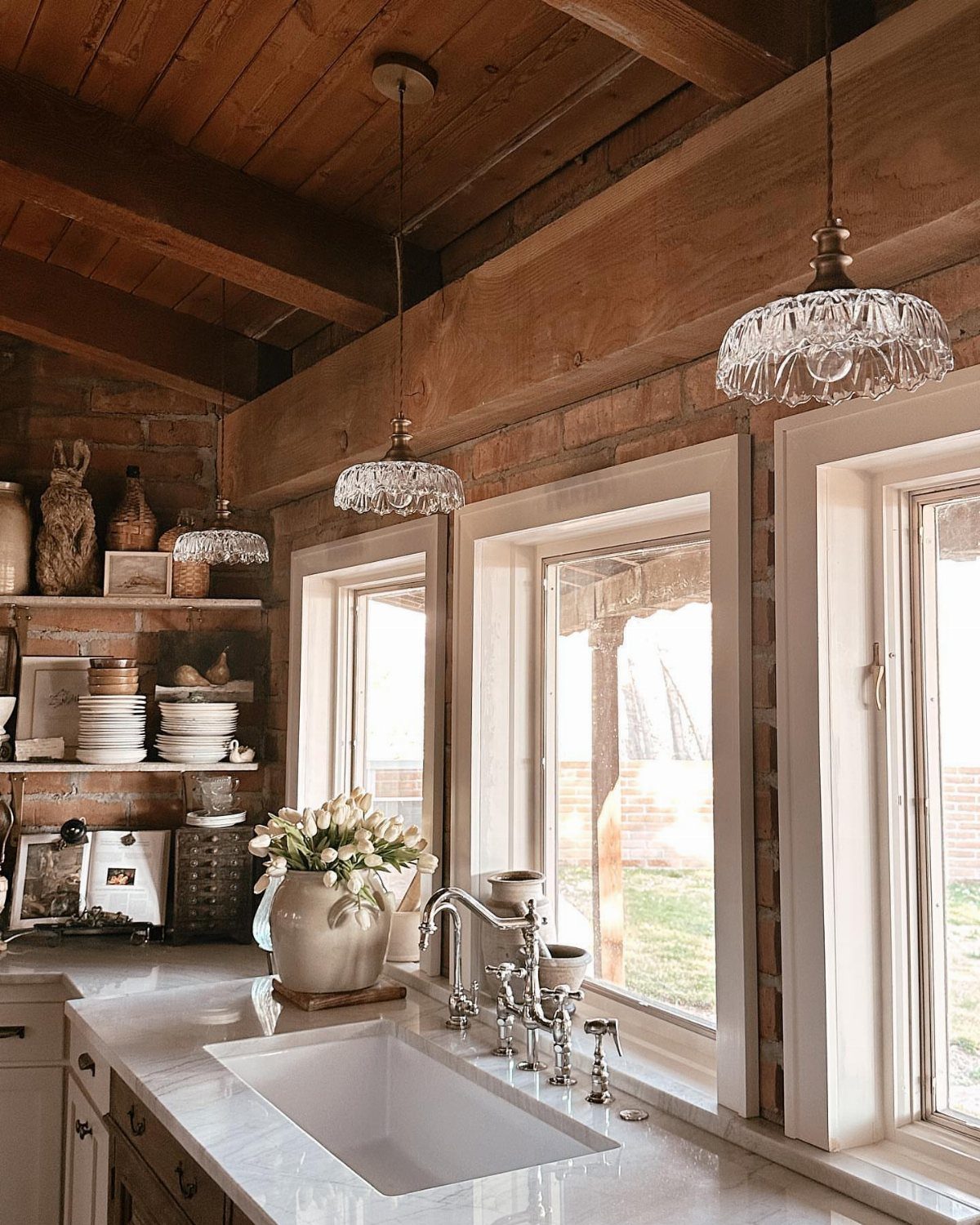 Vintage Kitchen Lighting Fixtures: 12 Pendant and Sconce Ideas 12 Vintage glass pendant lights hanging over a marble kitchen counter in a rustic room.