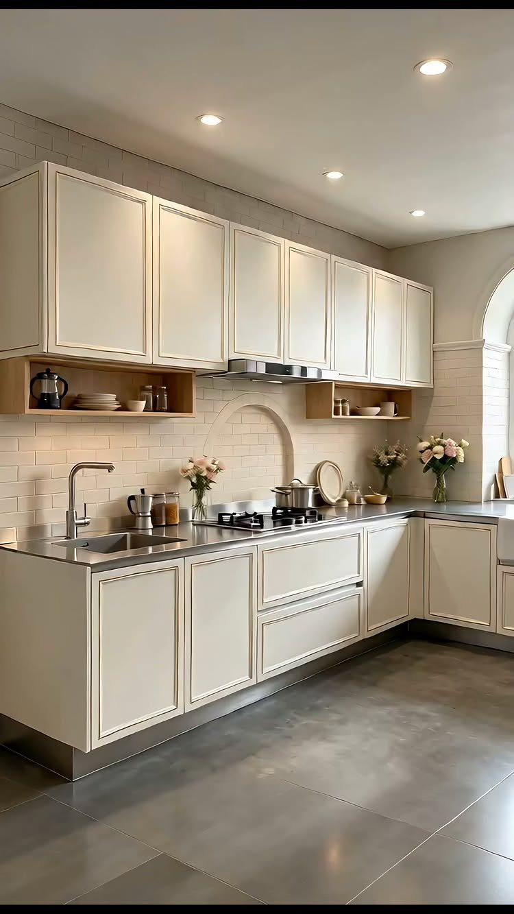 Light cream shaker cabinets in a kitchen with grey countertops and white brick walls